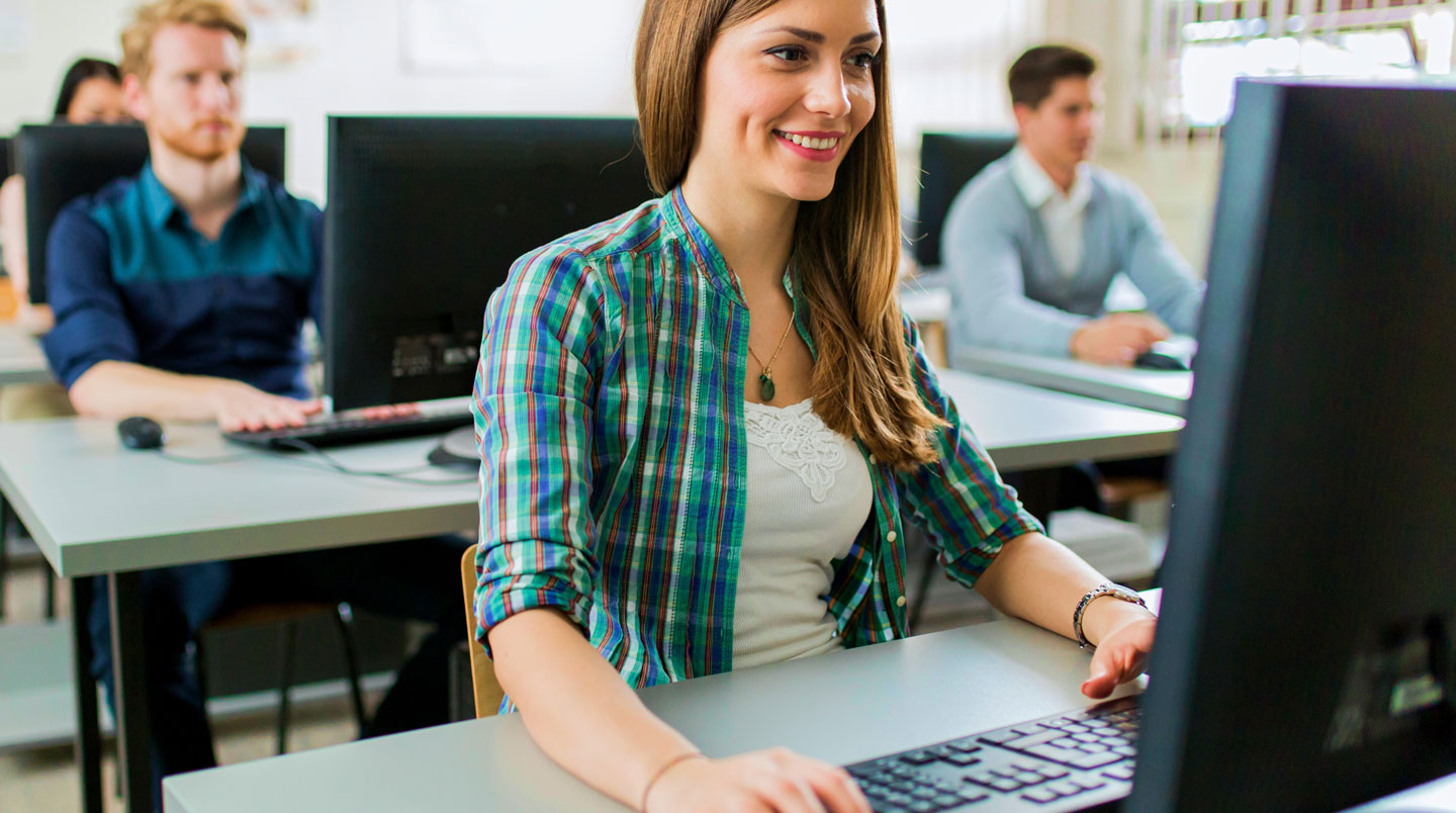 Personne adulte au bureau regardant un écran d'ordinateur avec aisance visuelle grâce à des lentilles de contact sclérales pour kératocône