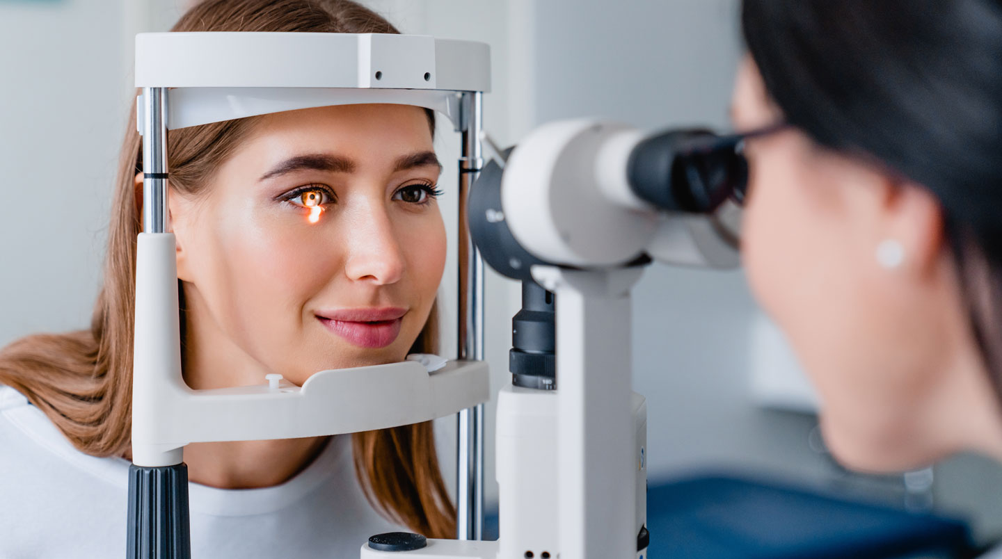 Un opticien-contactologue spécialisé examine la topographie cornéenne d'un patient sur écran pour adapter des lentilles sur mesure kératocône
